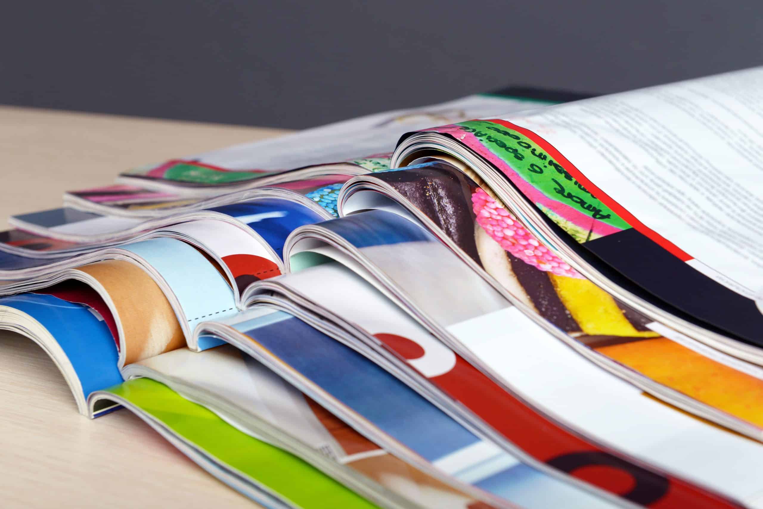 Stack of colorful printed booklets on a desk, showcasing custom booklet printing in Singapore with vibrant designs and corporate presentation styles.