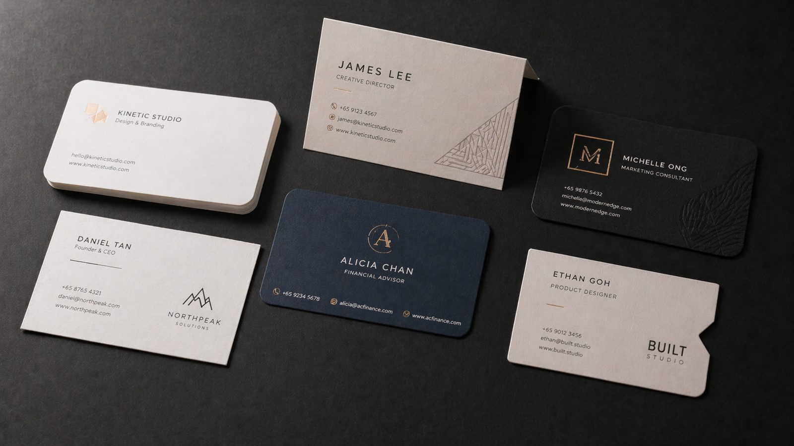 Assorted business cards standard, folded and die-cut on a dark matte surface