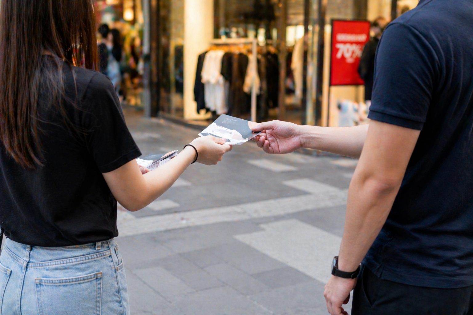 Flyer distribution on a Singapore street outside a retail shop