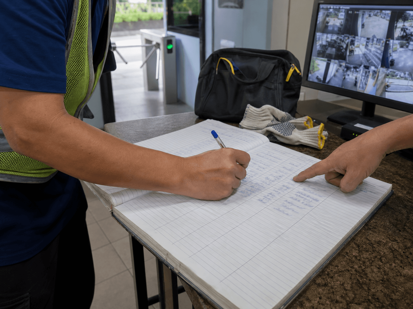 Estate contractor signing a printed log book at a condominium security counter